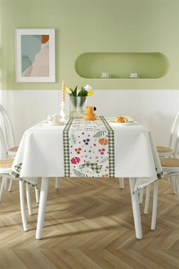 Detailed pattern of Easter rabbits, colorful eggs and floral print on white tablecloth