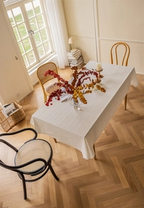 Detailed view of the white jacquard table cloth with textured vertical stripe patterns