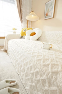 Close-up of white plush sofa cover with thick jacquard geometric diamond texture
