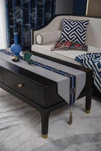 Close-up of new Chinese style table runner with grey fabric and golden tassel details