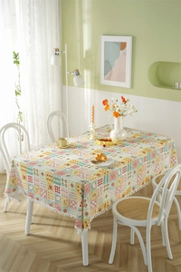Detail of French floral cotton tablecloth featuring white pom-pom trim and vintage patterns