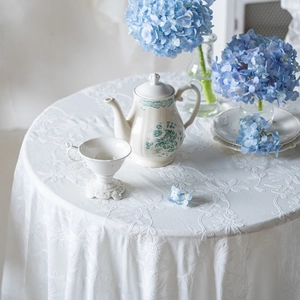 French style white cotton tablecloth with heavy floral embroidery and ruffled edges
