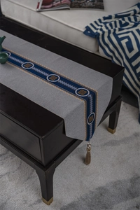 Detailed view of grey Chinese table runner with blue geometric patterns and tassels