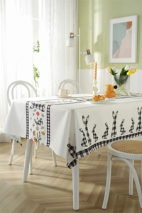 Detail of Easter tablecloth with plaid rabbits and spring flowers on premium fabric