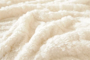 Detail of plush off-white jacquard faux fur fabric with soft texture for sofa covers