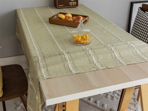 Detail showing light green jacquard tablecloth with white vertical embroidery lines