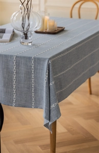Close-up of light blue rectangular tablecloth with white leaf-patterned embroidery textures