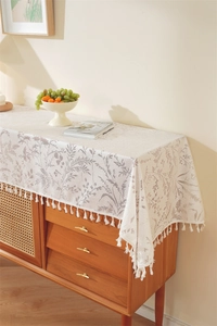 Detail of French rustic table runner with floral patterns and delicate white tassels