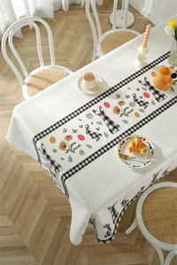 Detailed view of Easter tablecloth featuring plaid bunnies and spring floral patterns