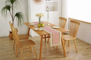 Detail of red diamond pattern and fringe on woven cotton linen farmhouse table runner