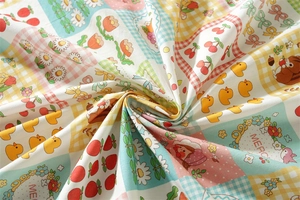 Detail of soft floral cotton tablecloth with cherry, daisy, and duck pattern prints