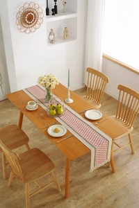 Detailed texture of cotton linen table runner with red and brown diamond weave and tassels