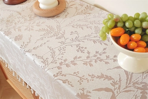 Detail of French country lace table runner with brown leaf jacquard and white tassels