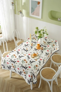 Detail of Easter tablecloth showing gingham rabbit, orange daisies and colorful eggs pattern
