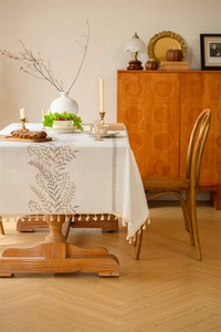Close-up of rectangular tablecloth with floral embroidery and tassel fringe details