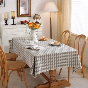 Tovaglia minimalista con motivo a rombi grigi e crema su un tavolo da pranzo rettangolare