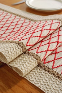 Detailed texture of cotton linen table runner with red diamond embroidery and fringes