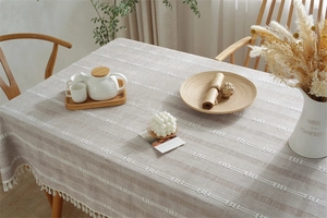 Close-up of Nordic woven tablecloth with striped jacquard patterns and elegant white fringe