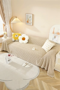 Close-up of plush jacquard texture on a thick beige full-cover sofa blanket