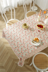 Close-up of vintage floral cotton tablecloth featuring white pom-pom fringe details