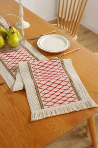 Detail of red diamond weave and tassel edge on cotton linen table runner with fringes