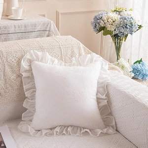 Detail of white cotton pillowcase with 3D floral embroidery and ruffled edges