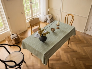 Detailed close-up of grass green tablecloth with white chain embroidery texture