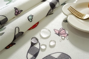 Close-up of waterproof polyester tablecloth showing beads of water on Easter rabbit print