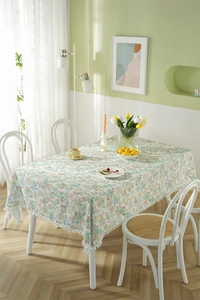 Detailed macro view of the floral cotton tablecloth edge with white pom-pom fringe decor