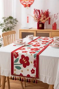 Detailweergave van een bruiloftstafelloper met rode bloemenpatronen en kwastjes