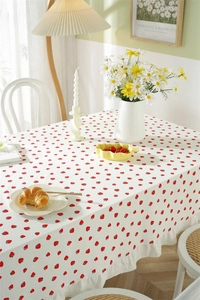 Close-up of strawberry print cotton tablecloth featuring delicate ruffle edge detail