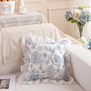 Detail of French floral cushion featuring blue botanical prints and elegant ruffled edges