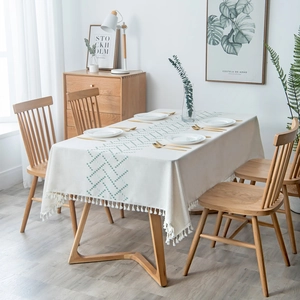 Boho tablecloth with green geometric embroidery and white pom-pom fringe details