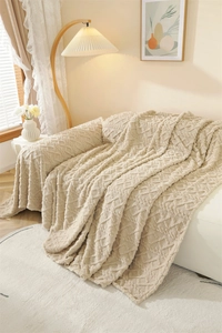 Detail of thickened plush sofa throw with jacquard texture and fringe edges