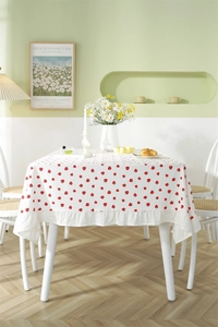 Close-up of strawberry print cotton tablecloth featuring decorative ruffled edges