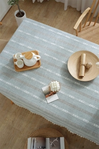 Detail view of Scandinavian polyester table runner with chic white tassel fringe and embroidery