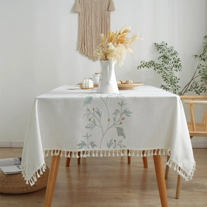 Bohemian embroidered floral tablecloth with cotton tassels on a wooden dining table
