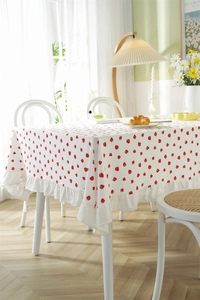 Close-up of strawberry print cotton tablecloth featuring ruffled edges and textured fabric