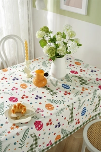 Detailed pattern of Easter eggs, green plaid rabbits, and spring flowers on tablecloth