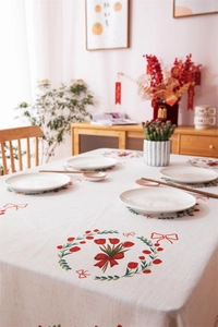 Detail of red tulip and bow print on a cream-colored linen fabric wedding tablecloth