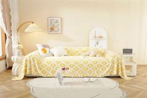 Close-up of plush yellow and white geometric jacquard sofa cover with fringe details