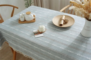 Detailed texture of blue jacquard tablecloth with geometric patterns and white fringe