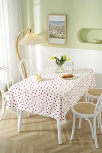 Close-up of strawberry print cotton tablecloth with white pom-pom fringe details