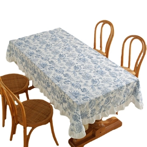 French style floral cotton tablecloth with blue ruffles on a vintage wooden dining table