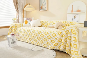 Detail of yellow and white jacquard sofa throw blanket with plush geometric diamond pattern