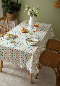 Detail of floral cotton tablecloth featuring ruffle edges and fresh strawberry patterns