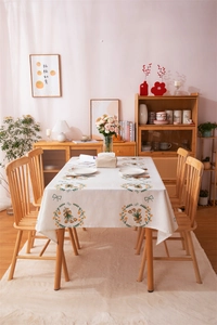 Detail of tulip wreath and ribbon print on a linen-blend rectangular tablecloth in dining room