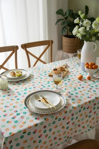 Detail of floral print cotton tablecloth with ruffle edge featuring strawberries and leaves
