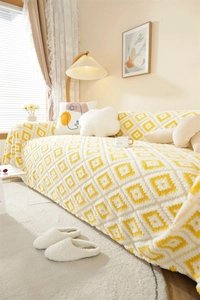 Detail of yellow geometric jacquard knit sofa throw with thick plush texture