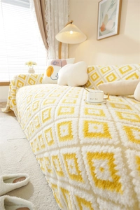 Detailed view of thick plush jacquard sofa throw with yellow geometric diamond pattern